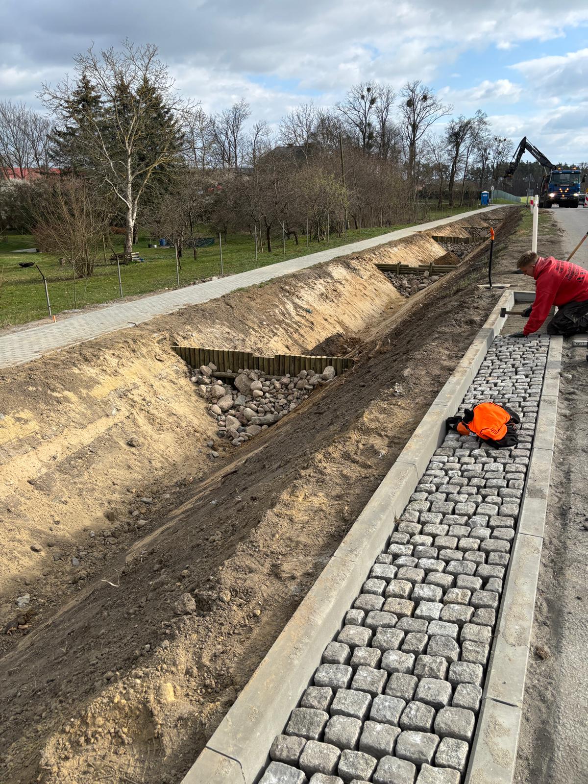 Zdjęcie przedstawia realizacje bruku przy drodze.