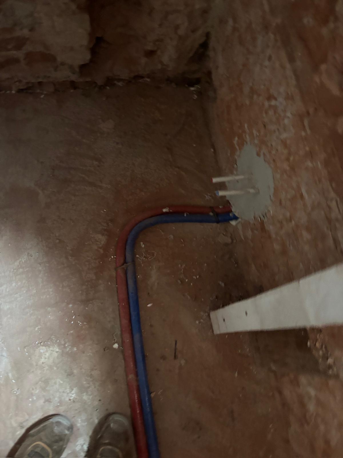 Zdjęcie przedstawia instalację wodną podposadzkową w budynku.