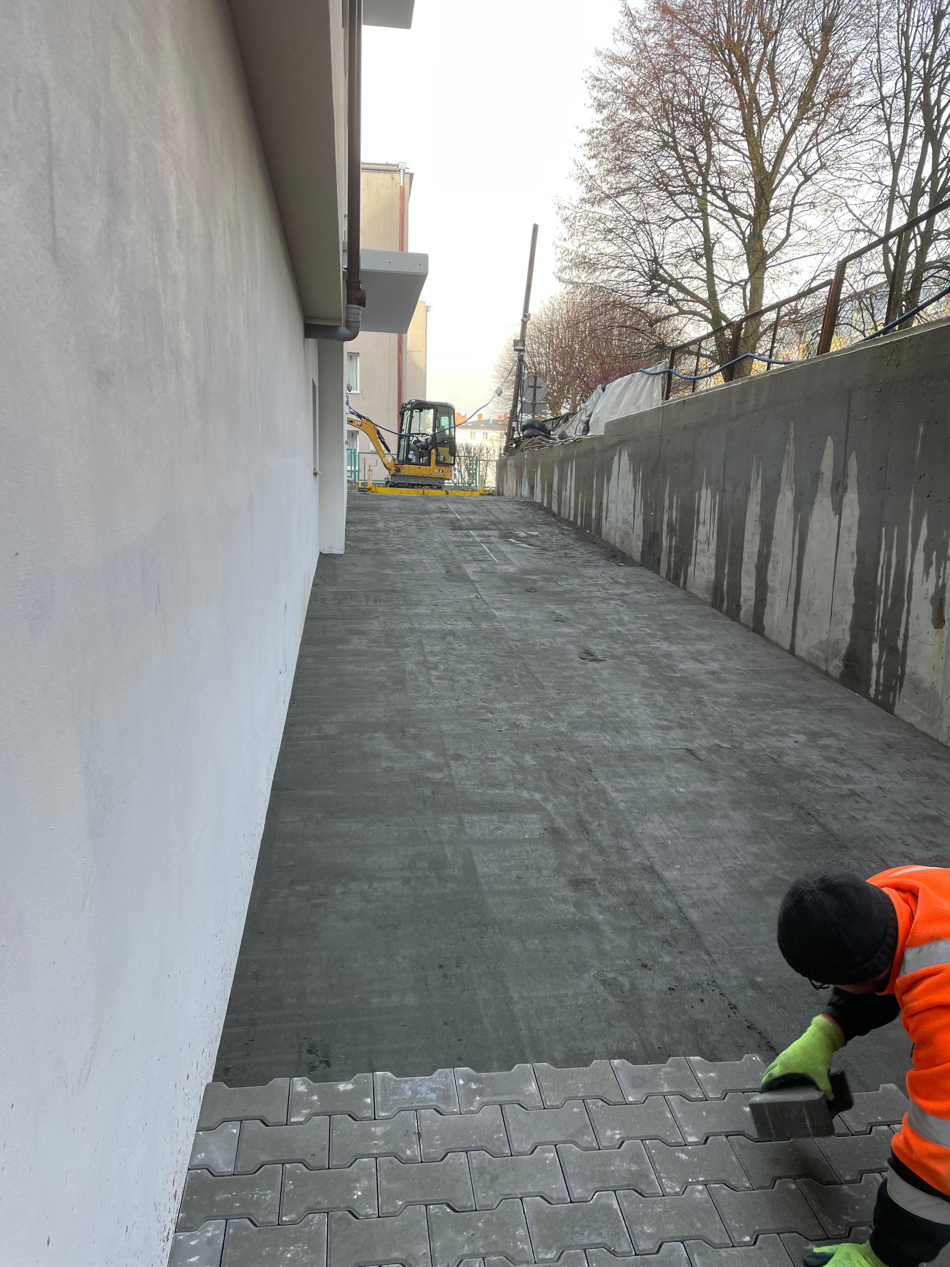 Zdjęcie przedstawia przygotowaną warstwę betonu pod kostkę na podjeździe w Gdańsku.