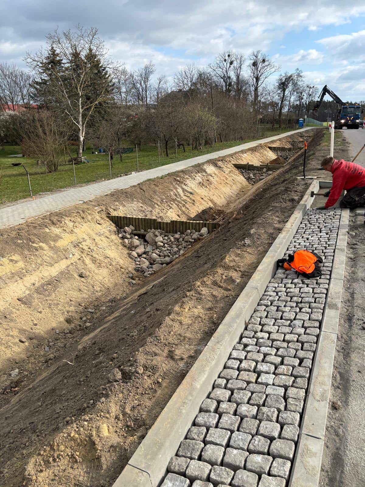 Zdjęcie przedstawia realizacje spływu przy drodze z bruku.